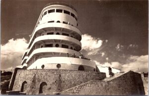 Istoria locului în imagini: prova rotunjită a clădirii văzută de jos, de pe plajă, pe o carte poștală expediată în 1958