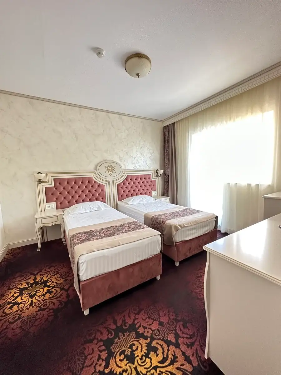 Cameră cu două paturi single și fereastră mare